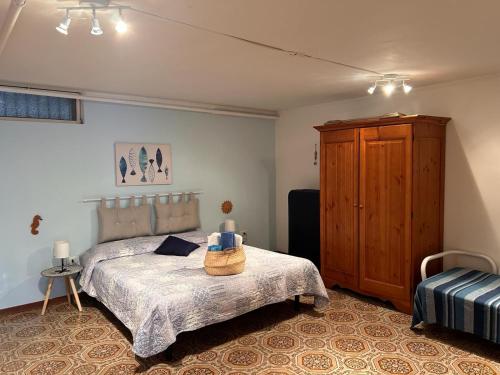 圣托·斯特凡诺·阿尔马尔Casa vacanze Marinella的一间卧室配有一张床和一个木制橱柜