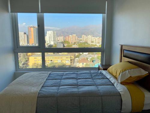 圣地亚哥Departamento ñuñoa的一间卧室设有一张床和一个大窗户