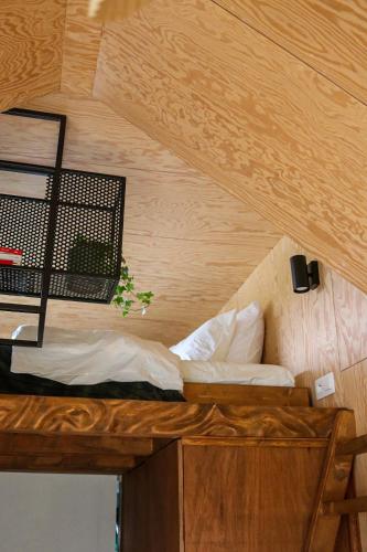 菲利普维尔Ekko tiny house的木天花板的客房内的一张床位