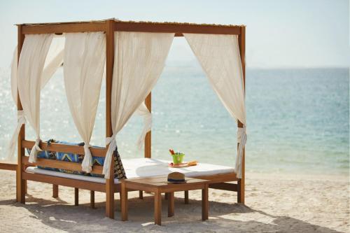 马萨阿拉姆Protels Beach Club & SPA的海滩上的一张床,背靠大海