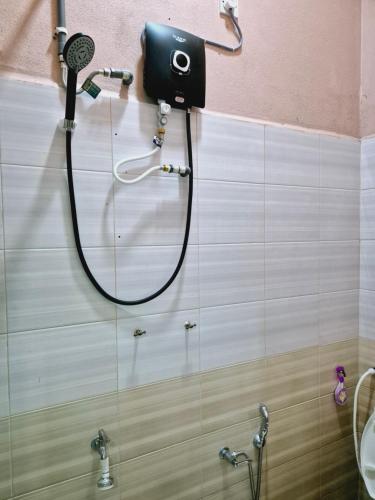 Pasir MasTeratak Che Esah Guest House FREE WIFI的浴室设有淋浴,墙上配有吹风机