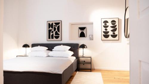 多瑙河畔克雷姆斯Smile Apartments im Stadtzentrum的卧室拥有白色的墙壁,配有一张带白色枕头的床。