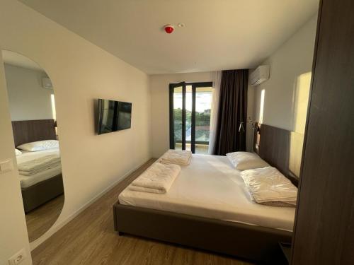 马卡尔斯卡Uzelac apartment with pool的酒店客房设有两张床和窗户。