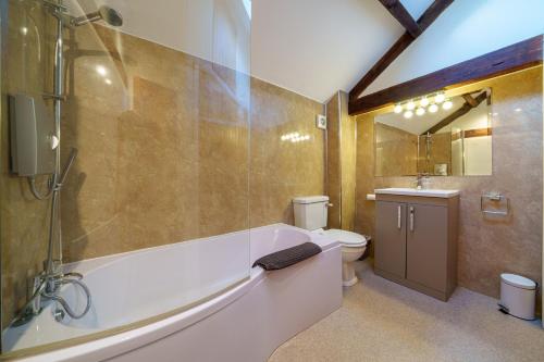 Armathwaite2 Eden Grove Cottages的带浴缸、卫生间和盥洗盆的浴室