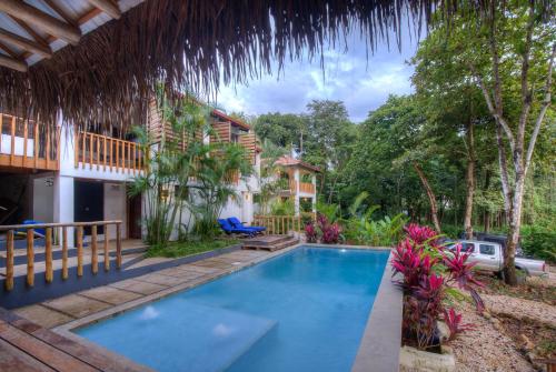 Playa PeladaTreehouse Chilo at Hacienda Nosara的房屋前的游泳池
