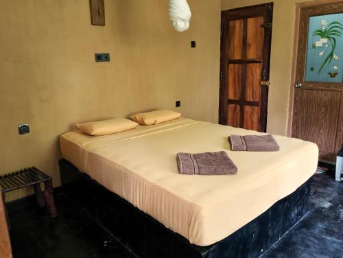 达瓦拉维Milk House Cottage的房间里的一张床位,上面有两条毛巾