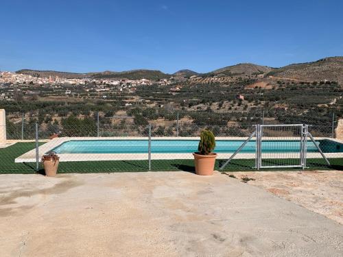 埃尔切德拉谢拉Casa la Umbría的一座带围栏的游泳池,旁边还有一座植物