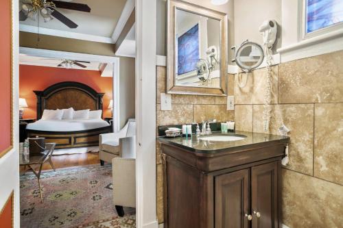 圣奥古斯丁Casablanca Inn on the Bay的一间带水槽的浴室和一间带一张床的卧室
