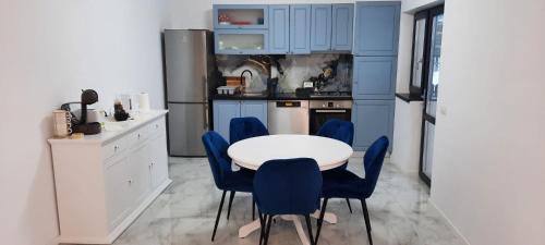 巴克乌Casa Bellevue的厨房配有蓝色橱柜和白色的桌椅