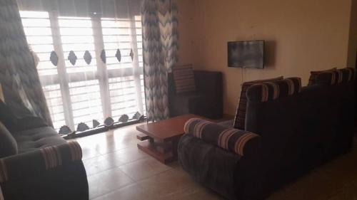MbaleNelly Apartments的客厅配有两张沙发和一台电视机