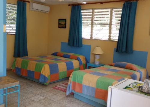 苏莎亚Casa Sylvie的一间卧室设有两张床和蓝色窗帘
