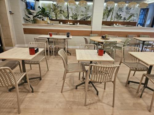 菲尼斯特雷Hotel Mariquito的用餐室配有桌椅和红杯
