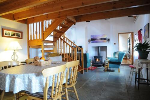 凯尔西温Cottage Skelligs Coast, Ring of Kerry的一间带桌椅和壁炉的用餐室