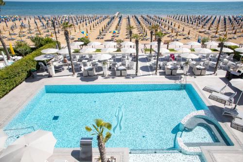 利多迪耶索罗赛扬那拉酒店的一个带椅子和遮阳伞的游泳池以及一个海滩