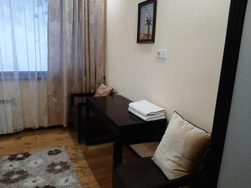 BesqaynarГостевой дом Almatau House的客房设有书桌、椅子和窗户。
