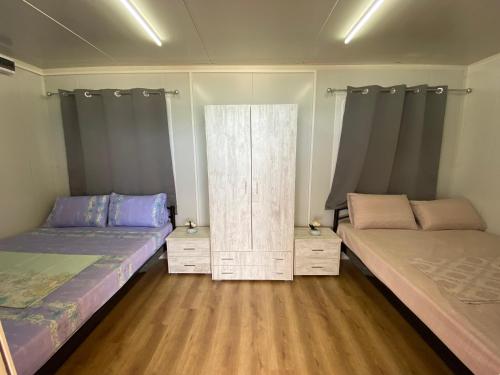 托罗尼Camping Anamour的一间设有两张床的房间和一个橱柜