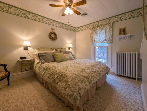 沃特金斯格伦Hudson Manor Bed & Breakfast的一间卧室配有一张床和吊扇