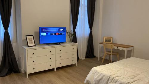 马拉加Suites Larios的一间卧室配有一张床,梳妆台上配有电视
