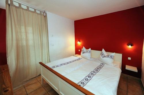 布尔格KASTANIENHOF的卧室配有白色的床铺和红色的墙壁
