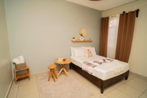 科潘省圣罗莎Cozy Renting Casa的卧室配有1张床、1张桌子和1把椅子