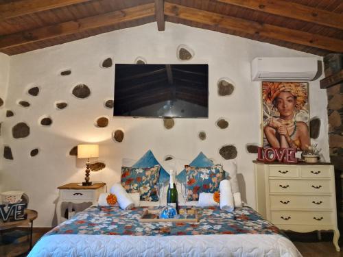 圣卢西亚Romantic Casa Rural La Molinera的卧室配有一张床铺,墙上配有电视