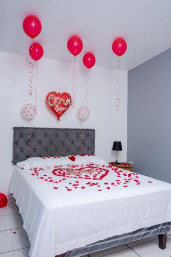 Santa AnaPosada La Rosa的卧室配有一张墙上红色心床