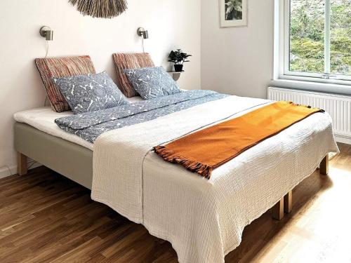 ArkösundHoliday home VIKBOLANDET II的一间卧室配有一张带蓝色枕头的大床