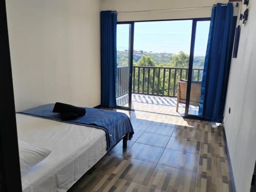 San JuanEl Paraíso Escondido的一间卧室设有一张床和一个美景阳台