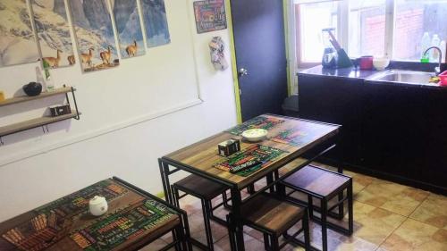 蓬塔阿雷纳斯Hostal Host Patagonia的厨房配有桌子、两把椅子和水槽