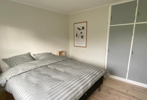 SkálavíkSTAY-Atlantic的一间卧室配有一张带条纹床单的大床