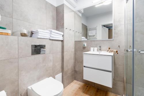 济夫努夫Apartament GRAN CANARIA Dziwnów Wybrzeże Kosciuszkowskie EPapartamenty的浴室配有卫生间、盥洗盆和淋浴。