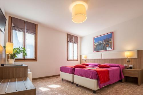 威尼斯伊尔摩洛威尼斯酒店的一间卧室配有一张大床和紫色毯子