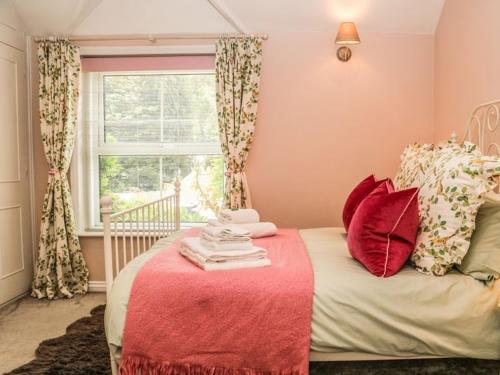 SelborneCharming Country Cottage的一间卧室配有一张带红色毯子的床和窗户。