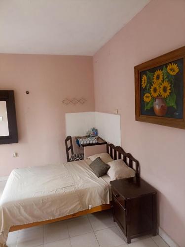 科苏梅尔Apartamento en planta alta, a pie de calle的卧室配有一张床,墙上挂着一幅画