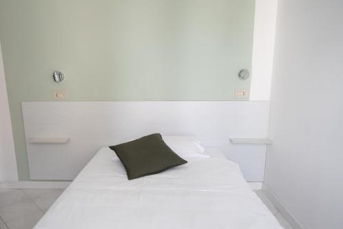 里米尼Hotel The Sea的一张白色的床,上面有黑色枕头
