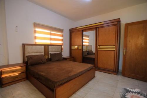 杰拉什Furnished apartment for rent in jarash شقة مفروشة للإيجار في جرش的一间卧室设有一张大床和一扇木门