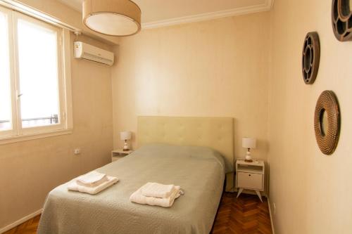 布宜诺斯艾利斯Calle 3 de febrero, departamento en Belgrano的一间卧室配有一张床,上面有两条毛巾