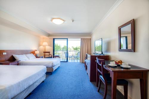 圣海伦斯Panorama Hotel St Helens的酒店客房配有两张床和一张书桌
