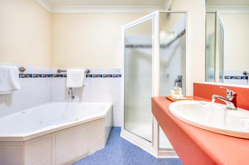 圣海伦斯Panorama Hotel St Helens的带浴缸、水槽和淋浴的浴室