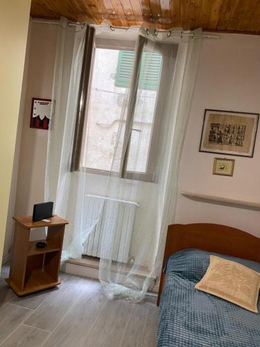 蒙塔约内Casa Borghellina的一间卧室设有一张床和一个大窗户
