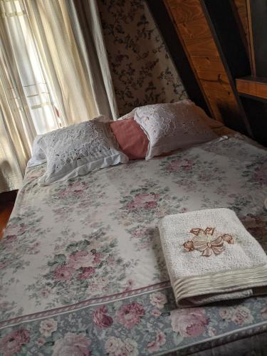 Villa AlsinaHabitación Boutique的一张带花卉床罩和枕头的床