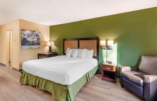 瓜斯蒂美式长居酒店 - 洛杉矶 - 安大略机场的一间卧室配有一张大床和一把椅子