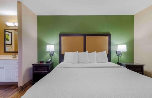 亚特兰大Extended Stay America Select Suites - Atlanta - Buckhead的一间卧室设有一张大床和绿色的墙壁