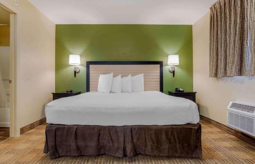 德斯坦德斯汀翡翠海岸公园大道US 98美国长住公寓式酒店的一张大床,位于酒店带绿色墙壁的房间里