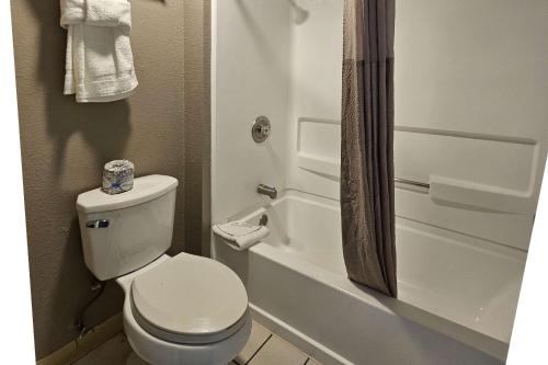 Thousand PalmsRodeway Inn & Suites Thousand Palms - Rancho Mirage的白色的浴室设有卫生间和淋浴。