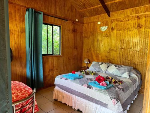 安加罗阿Cabañas Tangaroa y Hamea的木制客房内的一间卧室,配有一张床