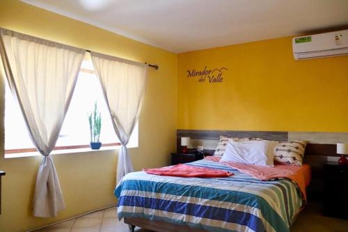 阿里卡Mirador del valle的一间卧室配有一张黄色墙壁的床