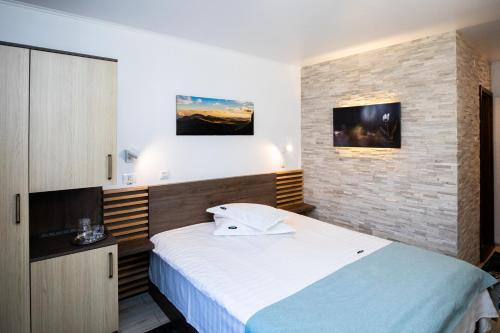 锡纳亚里维埃拉酒店的一间卧室设有一张大床和砖墙