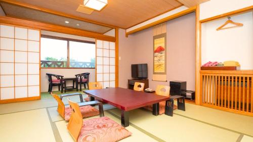 山中湖村Fuji Yamanakako Hotel的一间带桌子的客厅和一间餐厅