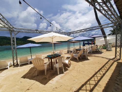 格兰德岛Casa de playa的海滩上摆放着桌椅和遮阳伞